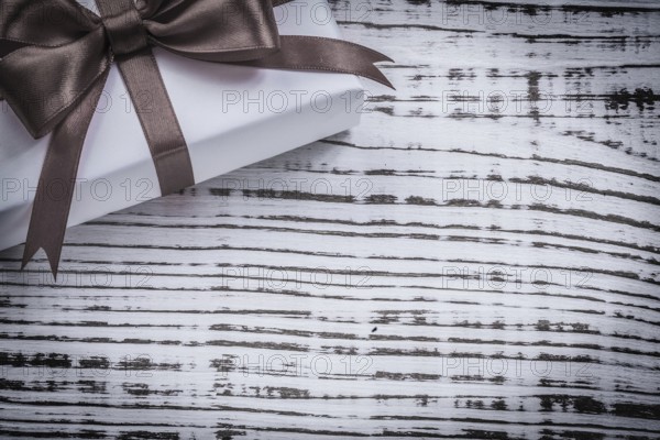 Wrapped present box red ribbon on vintage wooden board