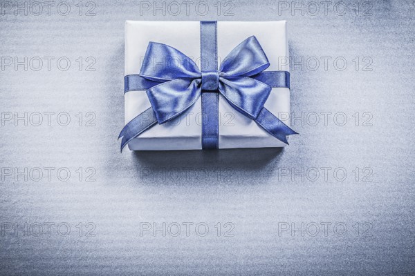 Packed present box with bow on blue background holidays concept