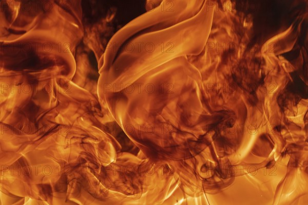Abstract red fire natural background with blaze. Beautiful dangerous firestorm abstract texture. Atmospheric dispersion, defocus (soft focus), motion blur from fire, high temperature from flames