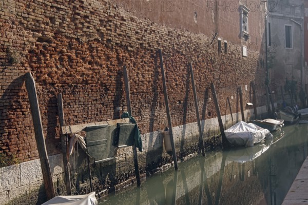 The outer wall of Arsenale: the old brick wall with moorings for small boats