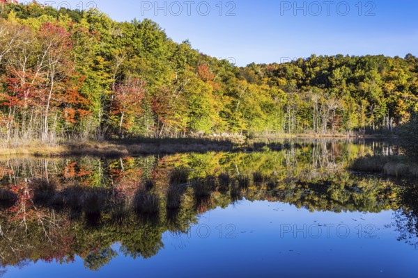 Magnificent resort in French Canada, the province of Quebec - Mont Tremblant. The water in the pond is smooth like a mirror. Concept of ecological and automobile tourism