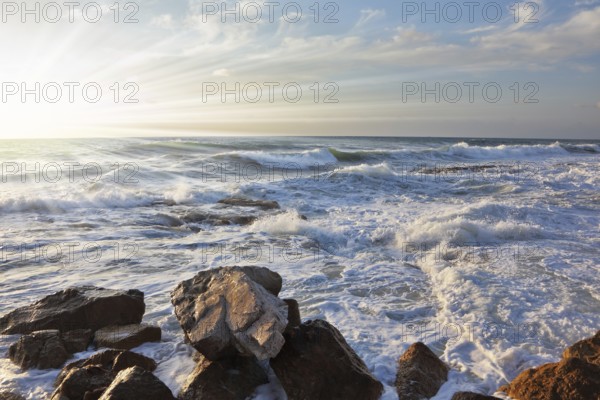 Magnificent sunset on Mediterranean sea. Storm waves break about breakwater stones on quay. Tel Aviv, spring