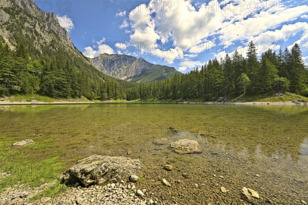 Green Lake in Styria during a summer day with people walking around the waterside