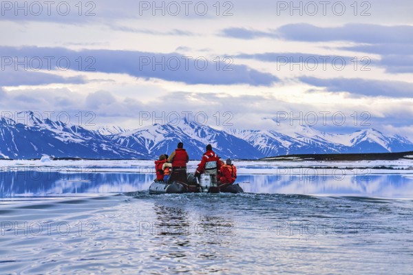 People travelling in inflatable boat at Svalbard