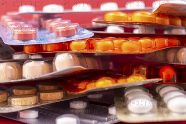 Different colorful capsules and pills in plastic packs - blisters stacked. Global pharmaceutical industry for billions dollars per year. Pharmaceutical drugs for use as medications. Studio shot