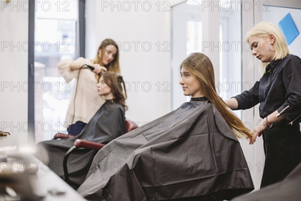 Beautiful woman combing wet hair. stylist brushing woman hair in salon. Hairdresser Serving Customer. Professional Young Hairdresser Working With Comb. hair care concept. Hairdresser Combing Wet Hair