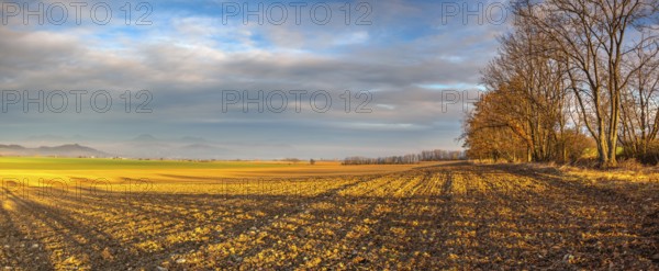 Autumn morning landscape over the city of Louny. Autumn plowed field at amazing sunrise. Czech Republic. Panorama image
