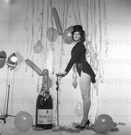 Champagne in the 1950s. A young woman in a scene that clearly is meant to suggest something to celebrate. A giant bottle of Delck champagne is part of the decor, balloons and confetti hangs in the background. Sweden 1952 ref BK84-4