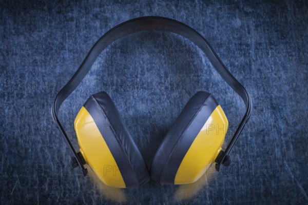 Noise reduction earmuffs on metallic surface construction concept
