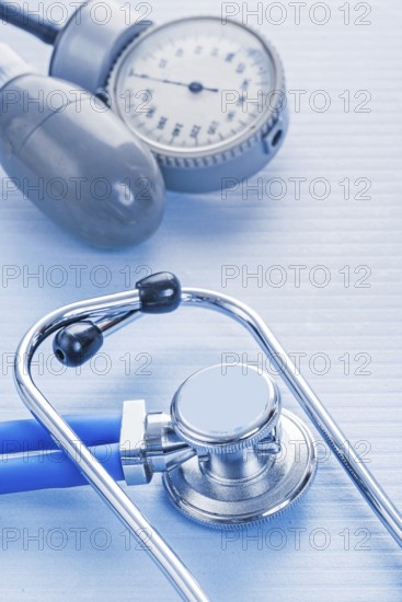 Stethoscope and blood pressure monitor on blue background medical concept