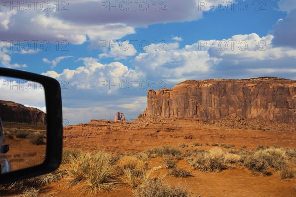 Monument Valley is a unique geological formation. The USA. Huge masses of red sandstone - outliers on the Navajo Indian Reservation. Reflection in a car mirror. The concept of photo tourism