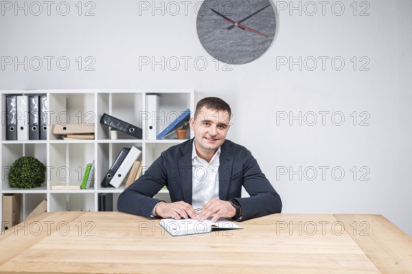 Portrait of a Caucasian male indoors posing in a jacket and white shirt. Overweight office worker at the workplace. The topic of obesity in sedentary inactive work. Fat business man