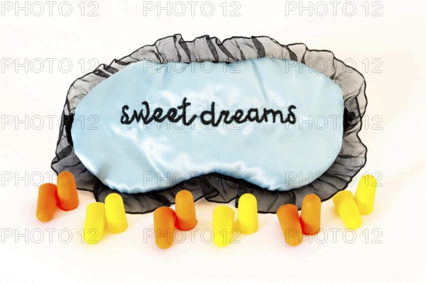 Sleeping mask with orange and yellow ear plugs isolated on a white background. Sweet dreams. Studio shot