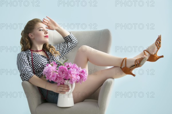 Retro girl on a chair with a bouquet of flowers