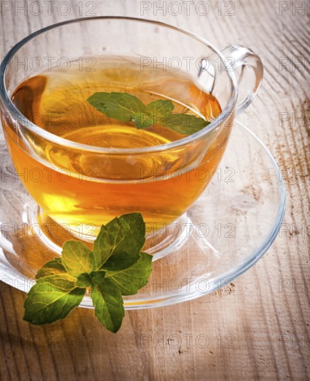 Mint tea in glass cup on wooden table