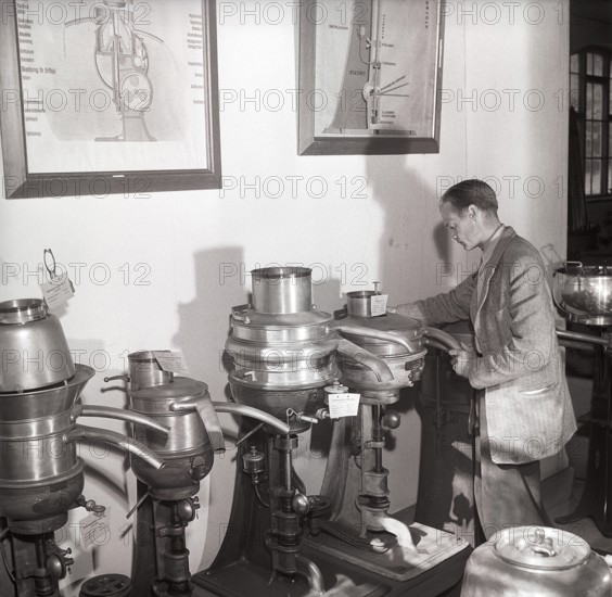 History of milk and cream making machinery. A man in a museum of separators. Machines made for the purpose of separating the cream and skim milk from fresh milk. By doing this it was possible to further process the cream into butter and cheese on a small scale. These separators were introduced in the late 1800s. Sweden 1953 ref BM26-4