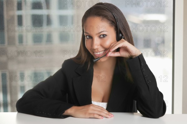 Corporate woman talking over her headset in an office