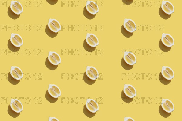 Conceptual pattern with halves of lemon collection with shadow on yellow background. Healthy eating, travel or vacation concept