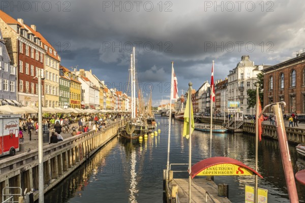 Copenhagen, Denmark, August 11, 2016: Nyhavn a cloudy day. It´s a 17th-century waterfront, canal and entertainment district in Copenhagen lined by coloured townhouses, it has many historical wooden ships