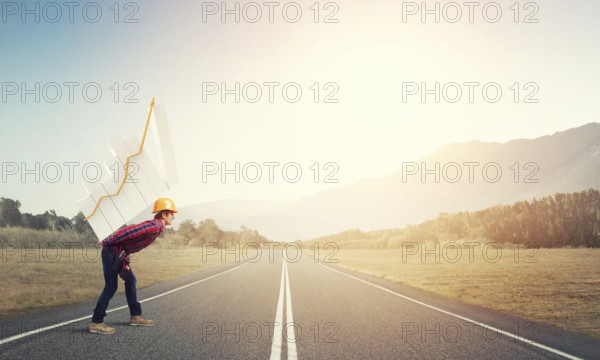 Young man builder carrying growing graph on his back