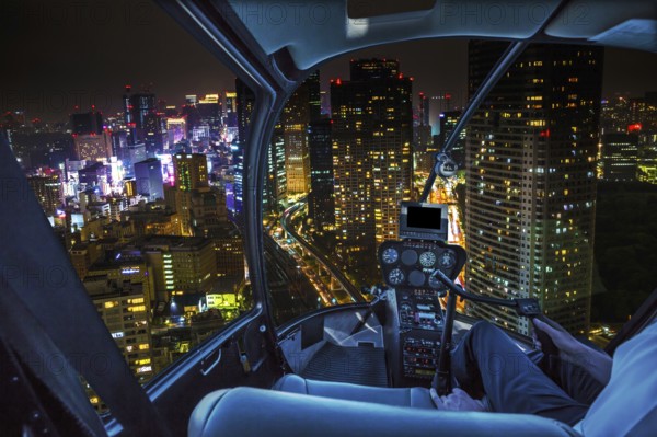 Helicopter flying over Tokyo cityscape and Shiodome skyscrapers and business offices view from skyline at night, Tokyo, Japan