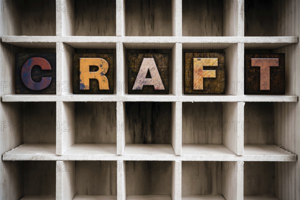 The word CRAFT written in vintage ink stained wooden letterpress type in a partitioned printer's drawer