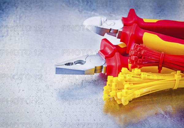 Nippers pliers self-locking cable ties on metallic background construction concept