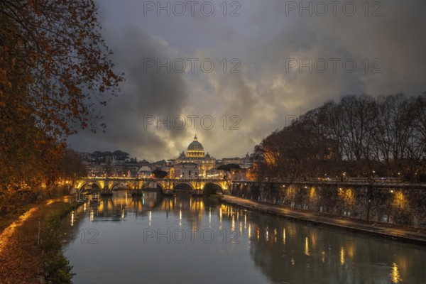 View over the river Tiber in a historic city. The old famous bridge Ponte Sant'Angelo, in the evening. Rainy weather at sunset and view of the Basilica of San Pietro, Rome, Italy