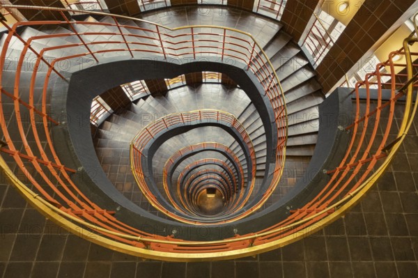Detailed spiral staircase with orange-coloured banister and tiled floor, fascinating and artistic, Kontorhausviertel, Old Town Hamburg, Free and Hanseatic City of Hamburg, Germany