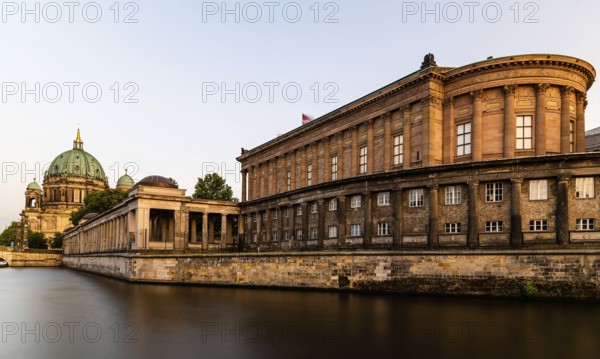 Scenic golden view of Spree river, Alte Nationalgalerie and Berlin Cathedral or Berliner Dom in Museum Island. Long exposure view at golden hour during sunset