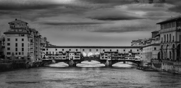 Beautiful black and white photo of the Ponte Vecchio, a medieval stone arch bridge over the Arno River, in Florence, Italy