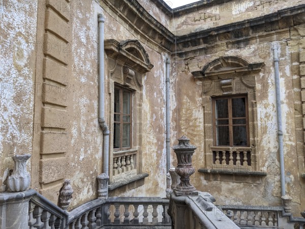 Weathered walls and ornate architectural details with classical windows and stone railing, Villa Palagonia, known as the ‘villa of monsters', is an 18th-century walled building located in Bagheria, Sicily