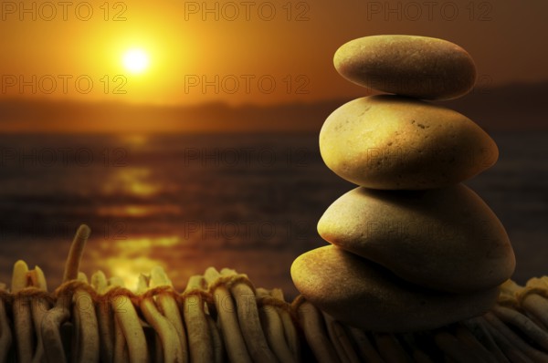 Stacked stones on wooden base for spa. Sunrise background