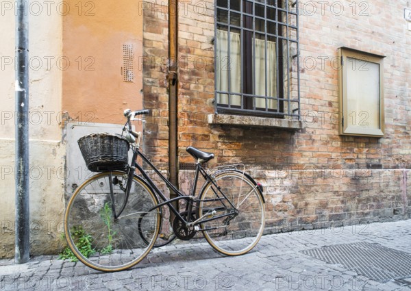 Old Italian bicycle on sunlight. Ancient buildings