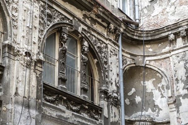 Dilapidated old building façade with stucco and ornaments