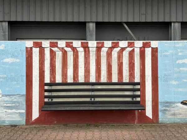 Bench with mural on a wall in the harbour, depicting a beach chair, Norderney
