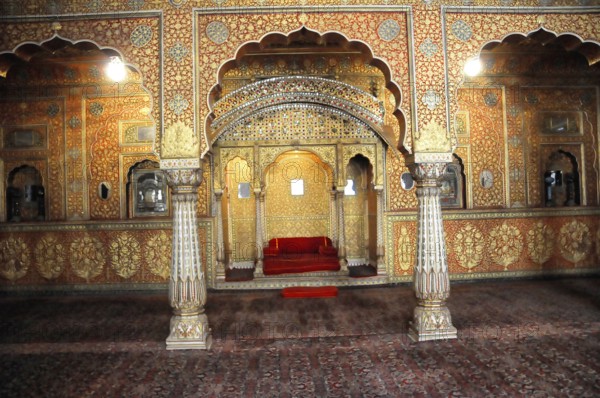 City palace in the fort of Jaisalmer, Rajasthan, India, Asia, A splendidly decorated room with columns and a red sofa in shades of gold, North India
