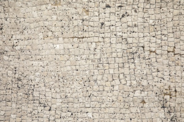 Mosaic floor as a texture of white little stones with dirt and crumbs