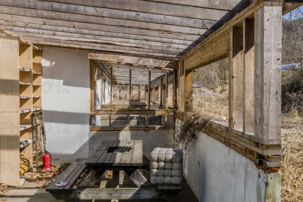 Chungju, South Korea, March 20, 2020: Back patio with decaying wooden picnic table at abandoned resort