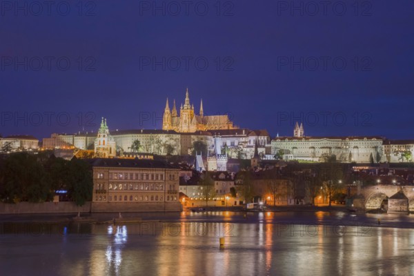 Vltava river with famous Hradcany castle and St. Vitus Cathedral in Prague, Czech Republic, by night