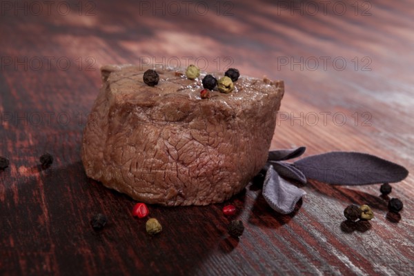 Luxurious sirloin steak on wooden background with peppercorn and herbs. Culinary red meat eating. Gourmet steak