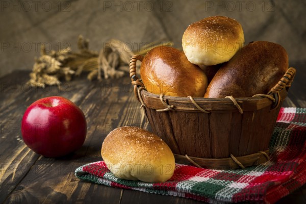 Baked apple pies in basket on wooden table