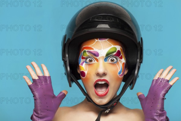 Portrait of a beautiful young model with bright creative make up with helmet