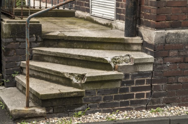 Dilapidated small stone staircase on house wall