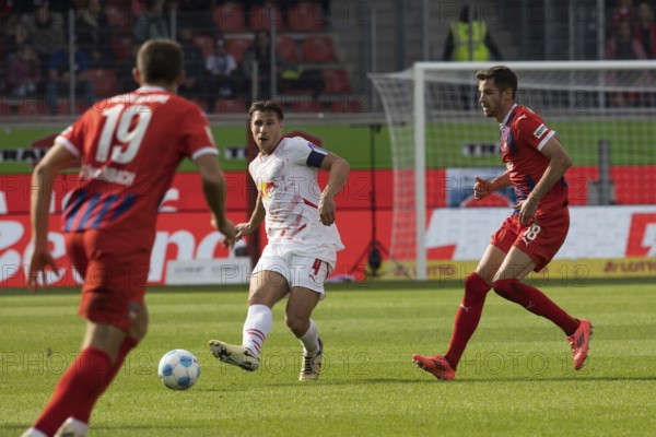 Football match, captain Willi ORBAN RB Leipzig centre with a pass into the deep, Marvin PIERINGER 1.FC Heidenheim right and Jonas FÖHRENBACH 1.FC Heidenheim watching from behind, football stadium Voith-Arena, Heidenheim