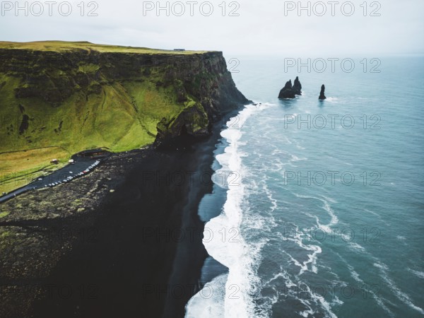 Volcanic Black Sand Beach with a view of Reynisdrangar. Waves crashing on the black sand beach. Vik, Iceland.