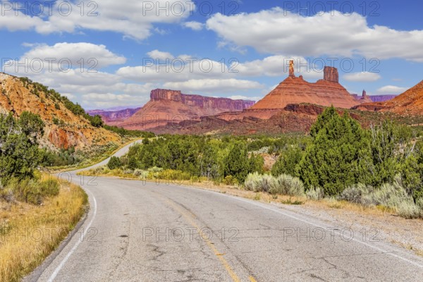 The reds and browns of Utah's vibrant landscapes. Wide asphalt highway among picturesque hills and rocks of bizarre shapes. US. Utah Red Sandstones