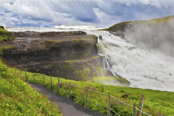 Powerful high-water waterfall in Iceland. For walks and observations on the hillside laid convenient path