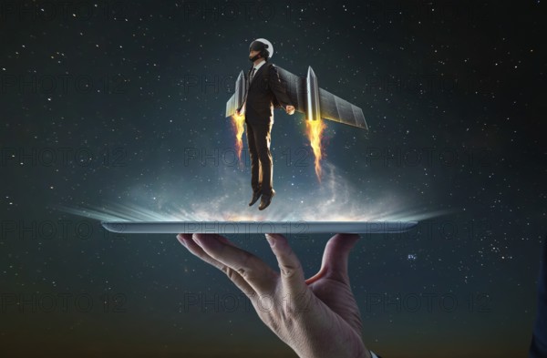 Waiter hand holding an empty digital tablet with Businessman wear a rocket suit to lift, Business success concept