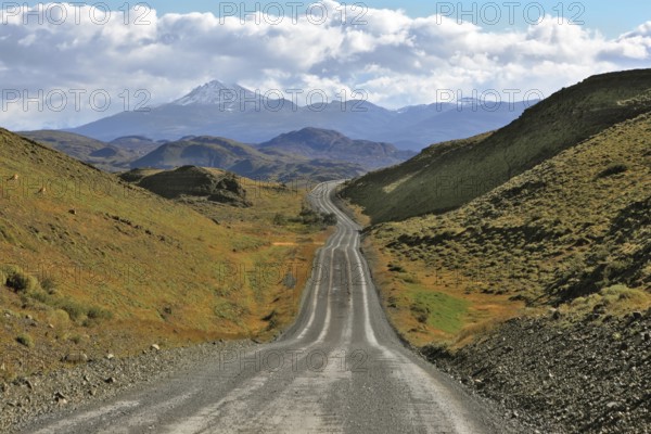 A gravel road winds among the hills and mountains. Chilean Patagonia. Summer in the national park Torres del Paine